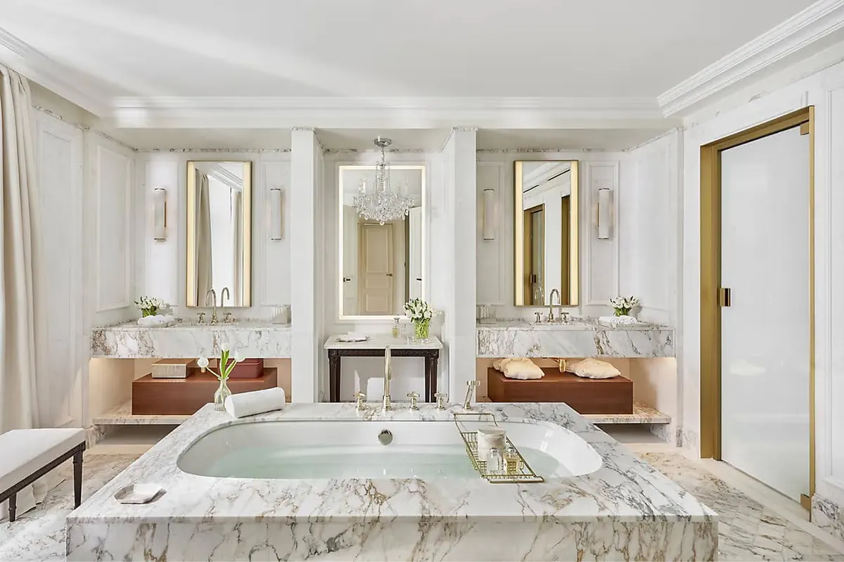 Spa bathroom with marble vanity, freestanding tub, and jewel-toned accents