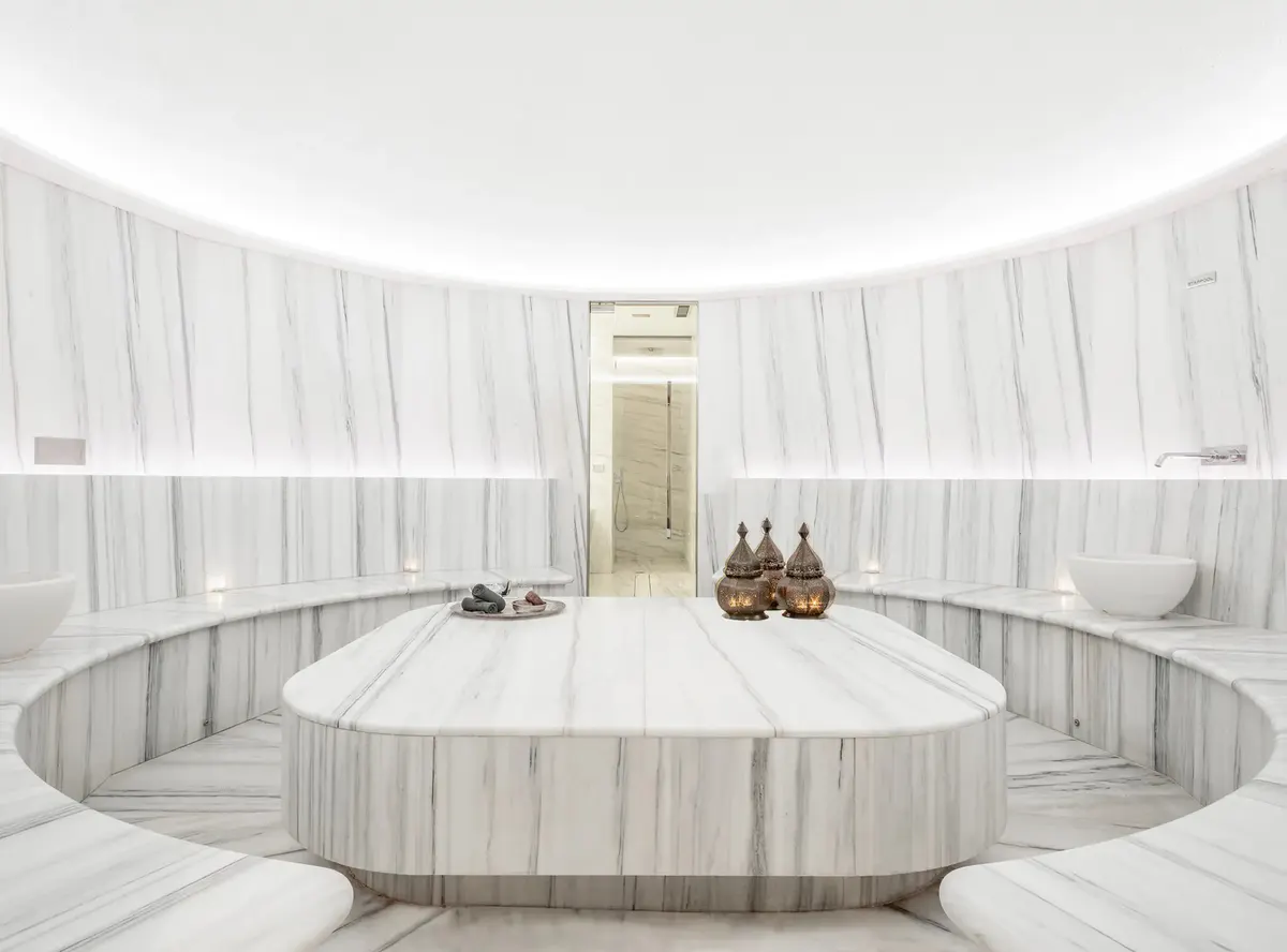 Spa relaxation room with circular bath in white chamber