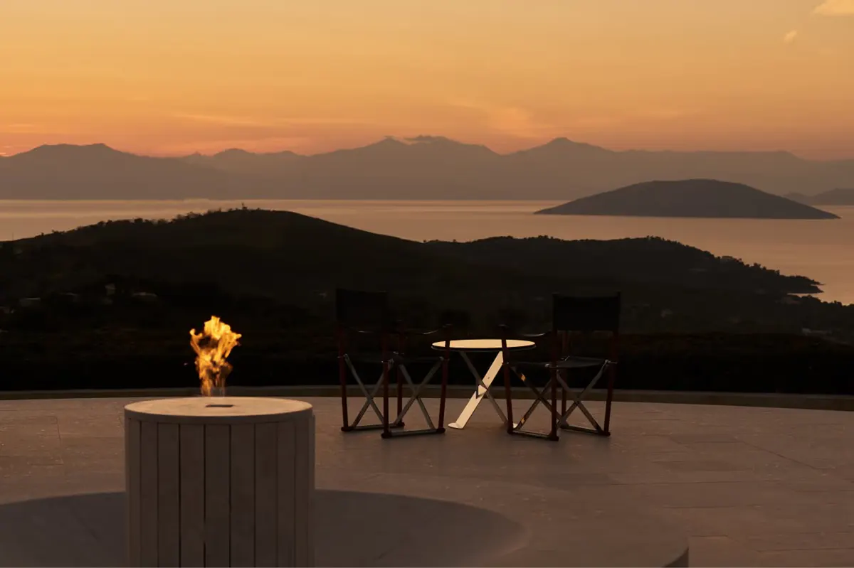 Sunset table setup with burning fire pit and mountain backdrop