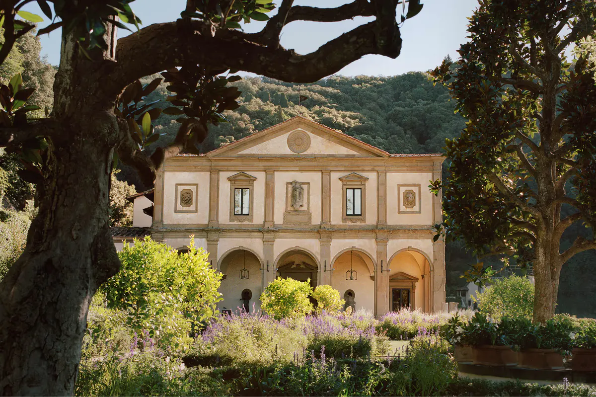 The Renaissance facade beneath cypress trees with Fiesole’s forested landscape beyond