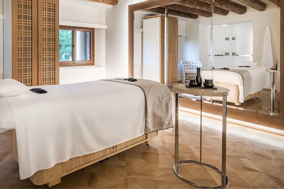 A fitness center with wooden beams, exercise equipment, and bright open space