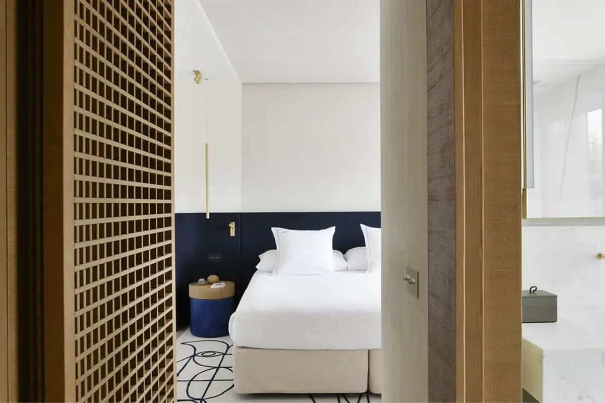 Hallway entry with wooden lattice door and white bedroom