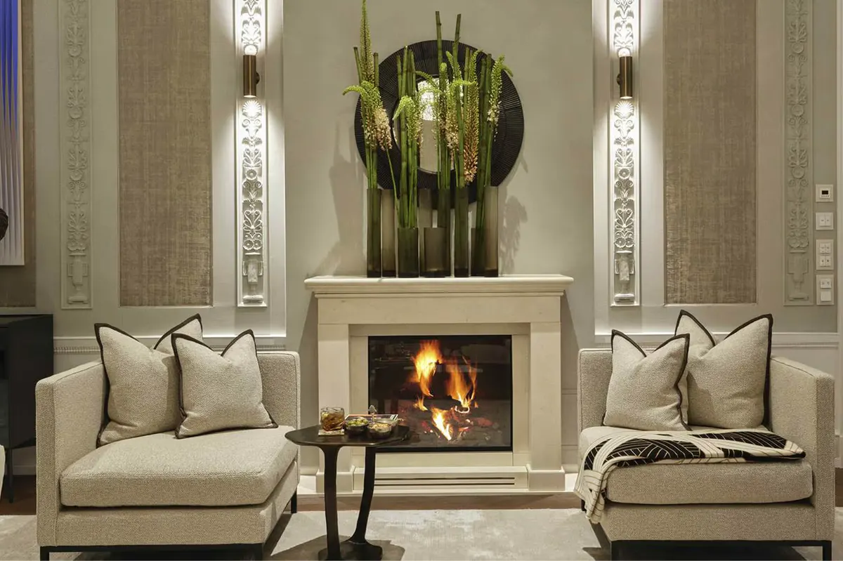 Symmetrical lounge with cream sofas flanking a central fireplace