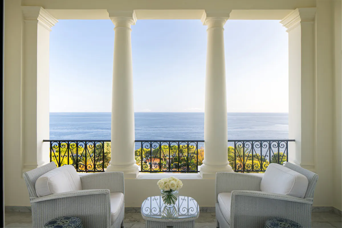 Three arched windows with sea views and armchairs overlooking the Mediterranean
