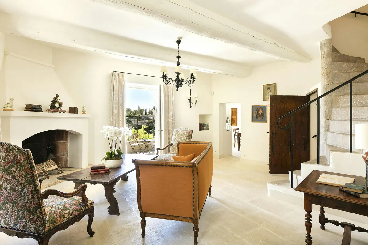 Suite with pale walls, chandelier, dining table, and garden view