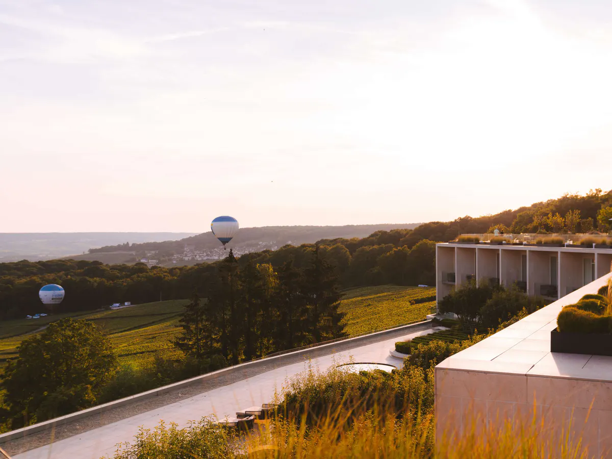 Terrace at dusk overlooking vineyards with hotel structure in soft evening light