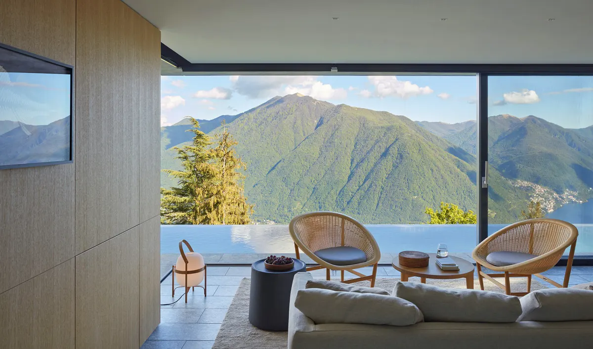 A terrace with lounge chairs and lake views framed by modern architecture
