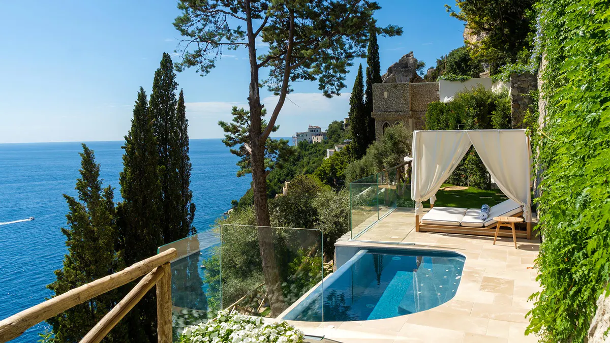 Private suite with infinity pool on clifftop terrace surrounded by cypress trees