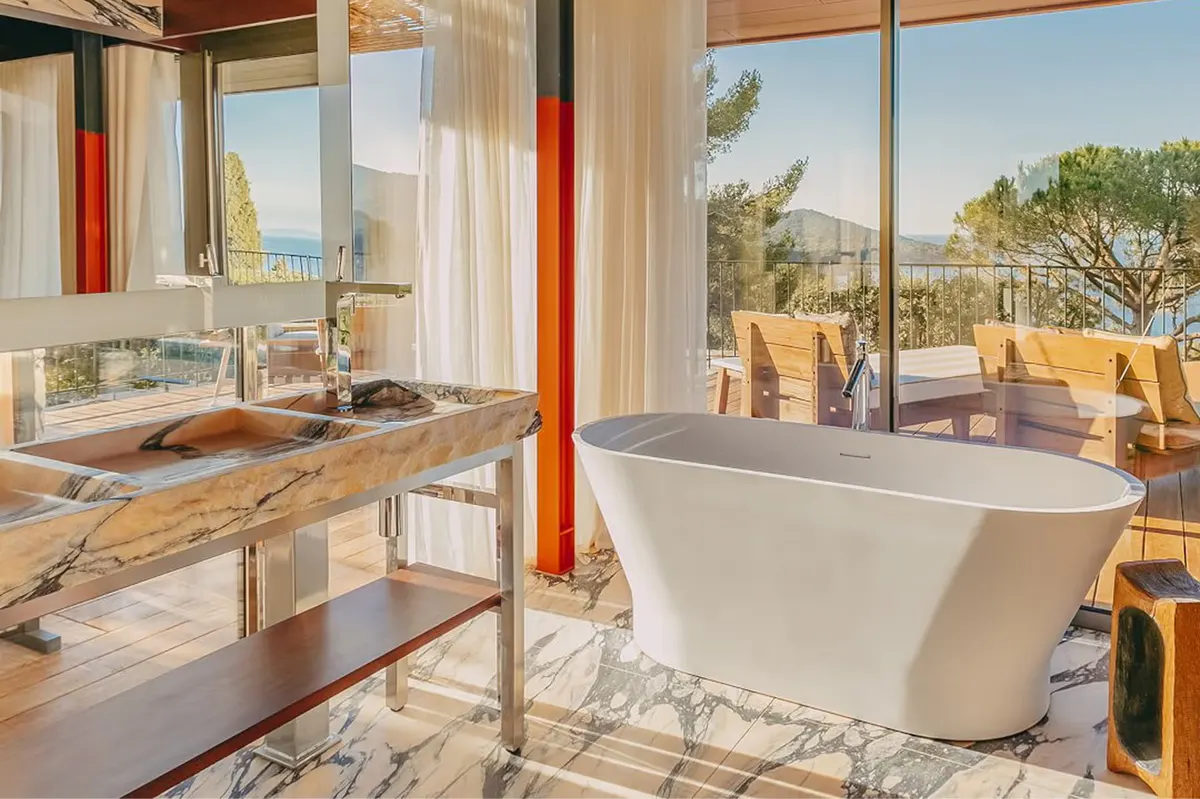 Spa bathroom with white soaking tub and morning light from windows