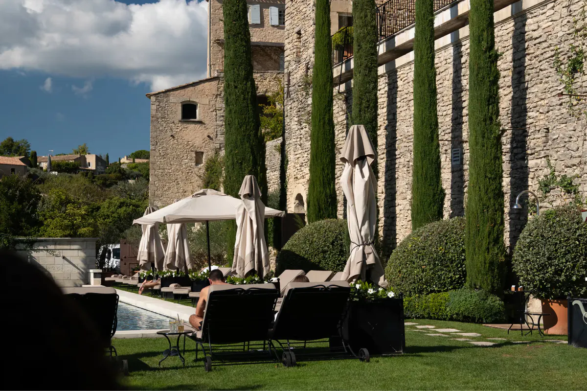 Manicured lawn with stone walls, shaded pavilion, and distant valley views