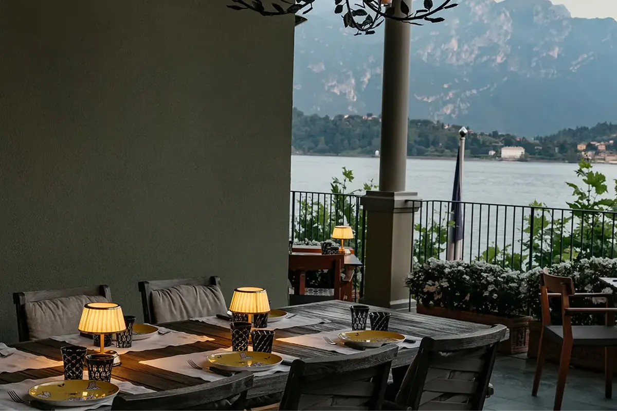 Dinner table with place settings and mountain-lake view through opening