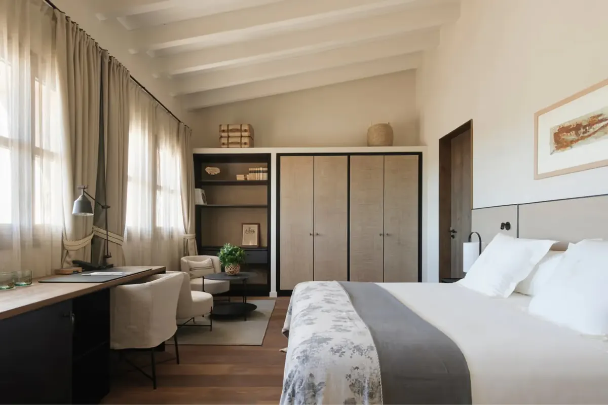 Master bedroom with built-in wardrobe, wooden beams, and garden views