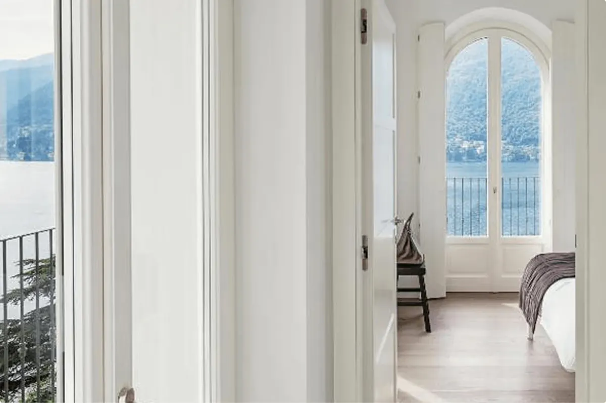 Bright hallway with tall arched doors opening to views of the lake
