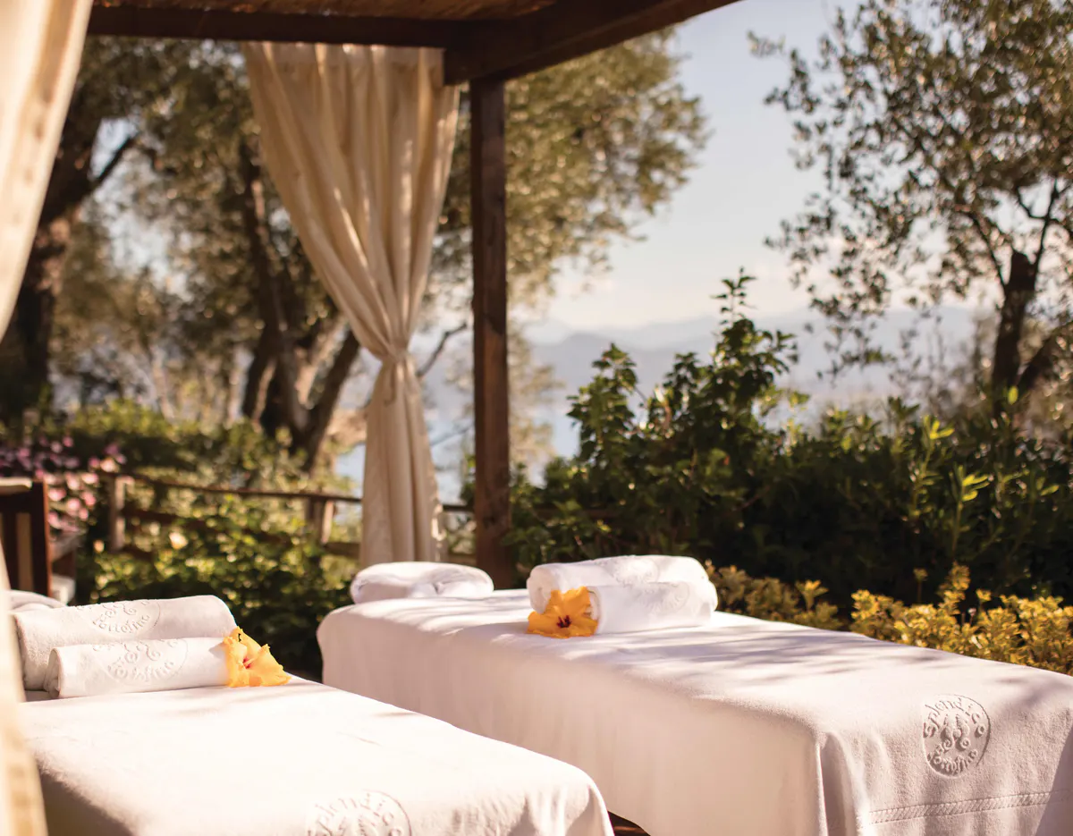 An outdoor spa area with draped cabanas and cushioned lounging platform