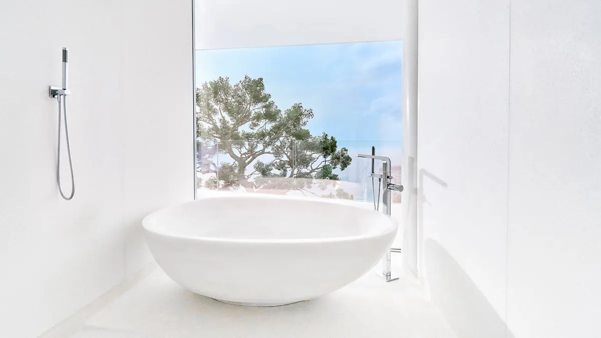 Soaking tub in white with ocean view through window