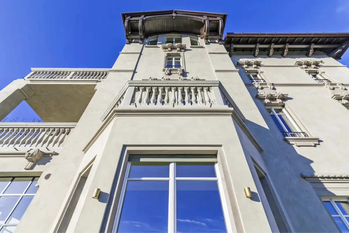 The stone and stucco facade of the main villa with traditional balustrades