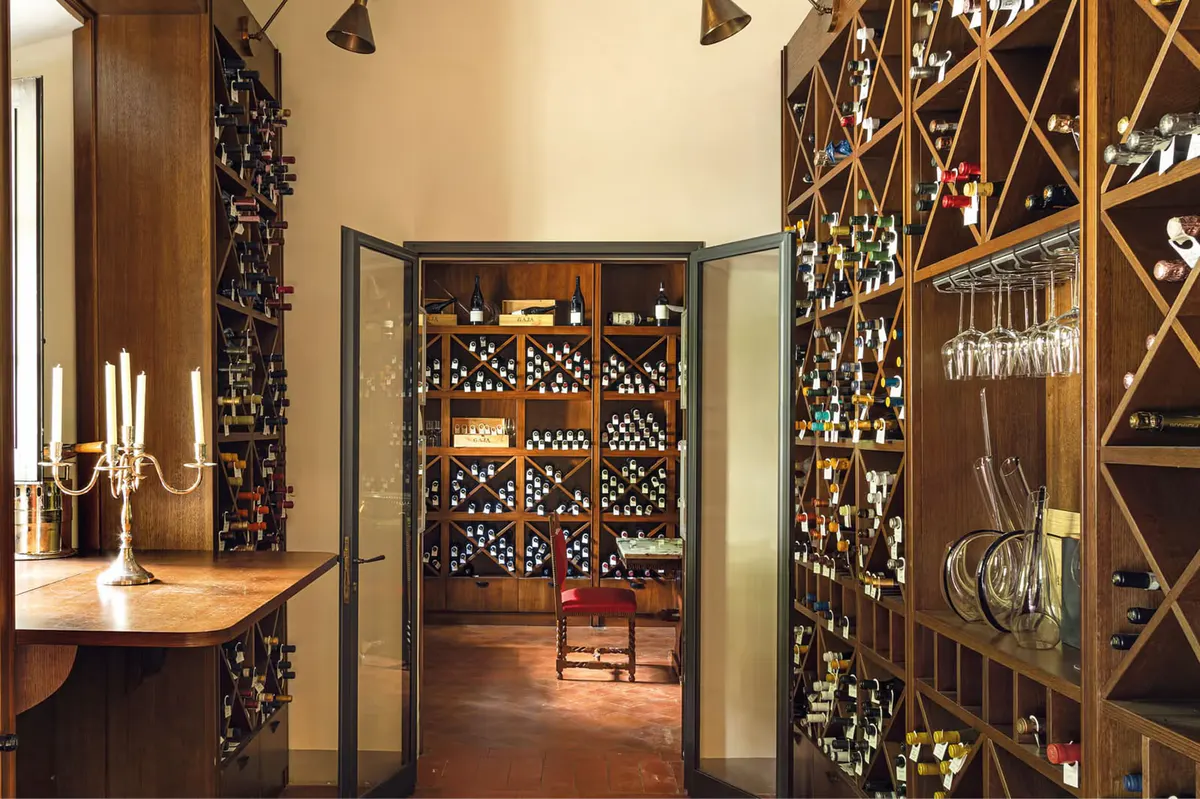 A wine cellar entrance with ornate wooden doors and interior wine storage racks visible