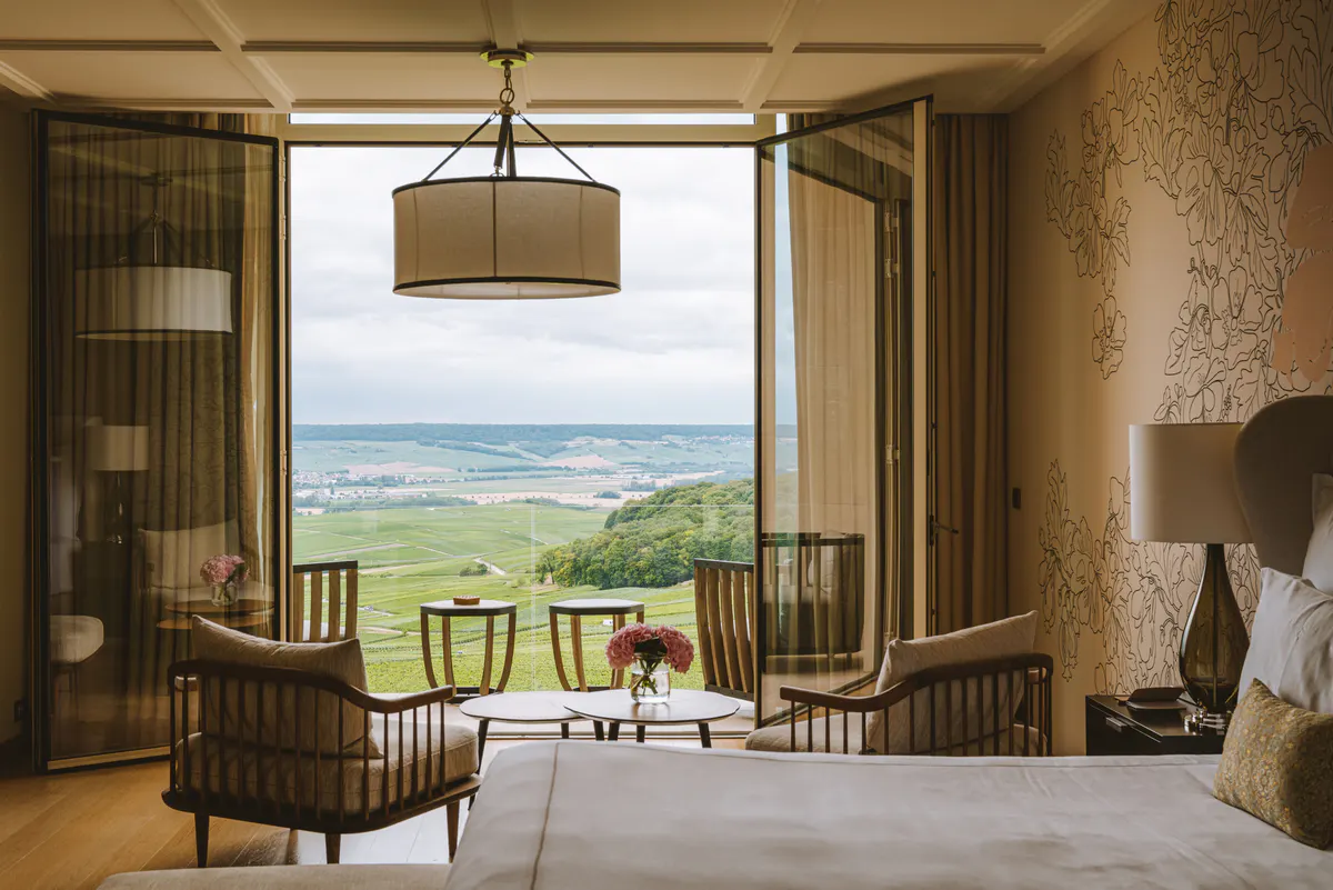 Sitting area with natural wood furnishings and expansive windows overlooking rolling vineyards