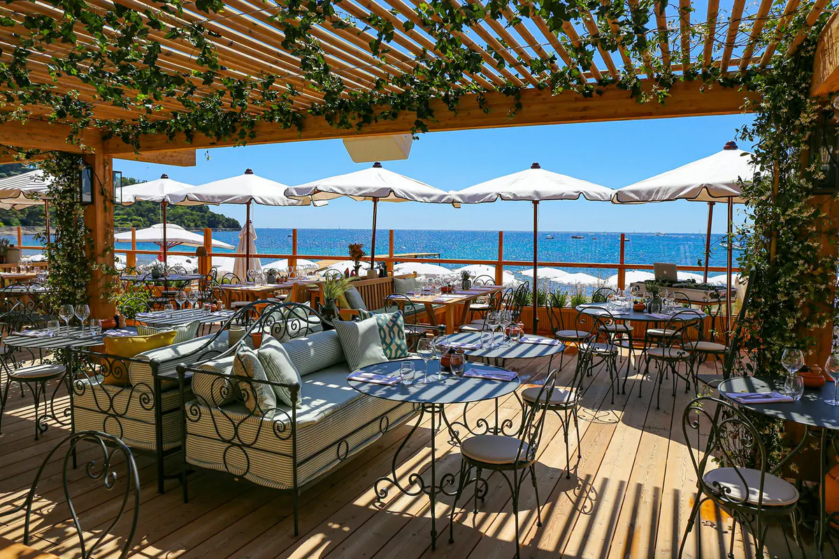 Waterfront dining terrace with latticed shade structure and panoramic bay views