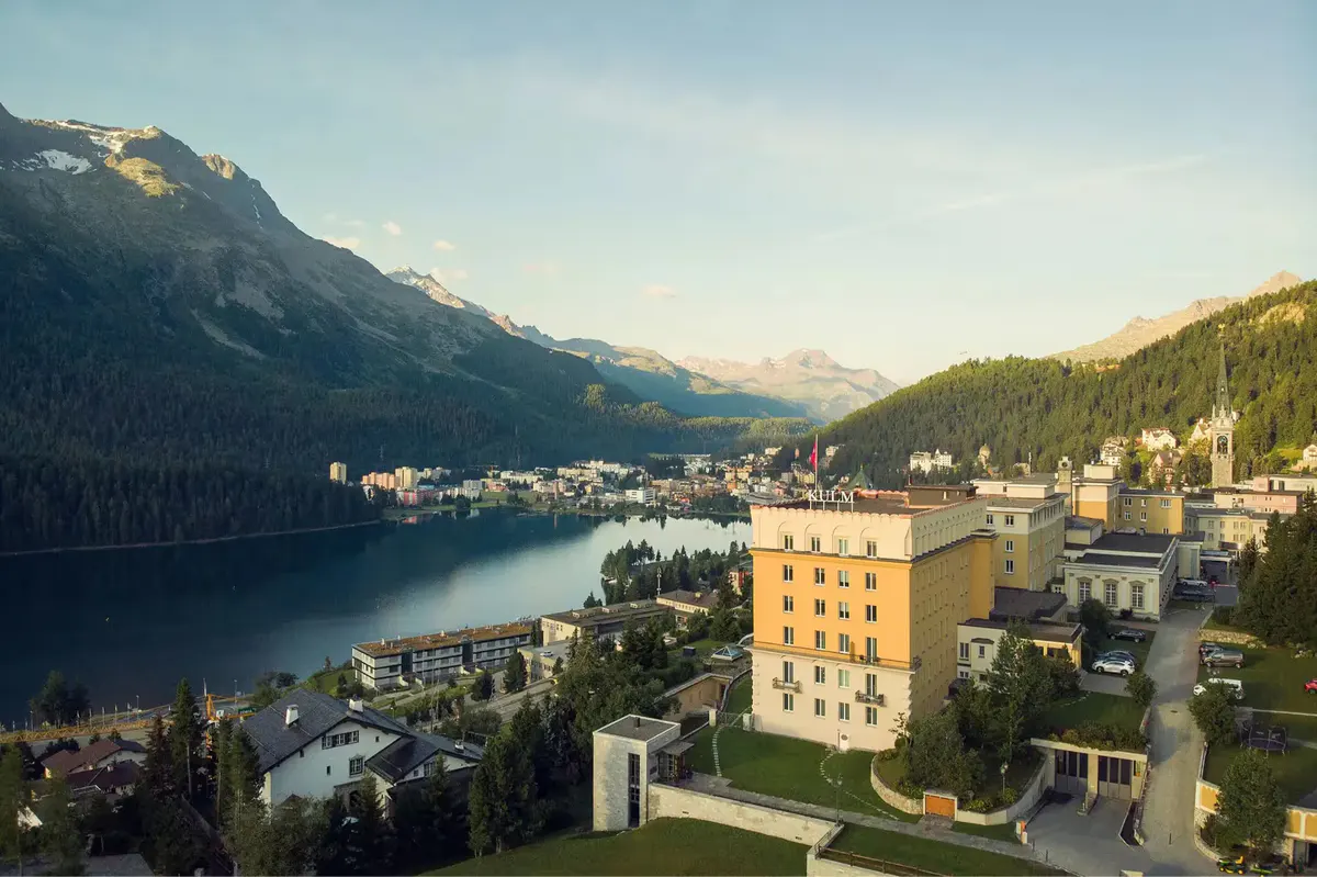 The lakeshore with the hotel overlooking the water and Alpine slopes beyond