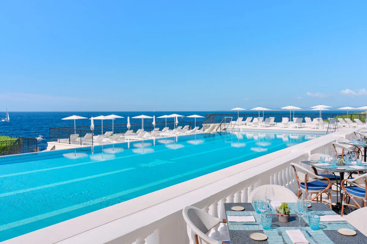Infinity pool overlooking the Mediterranean with cabana and sea-view horizon