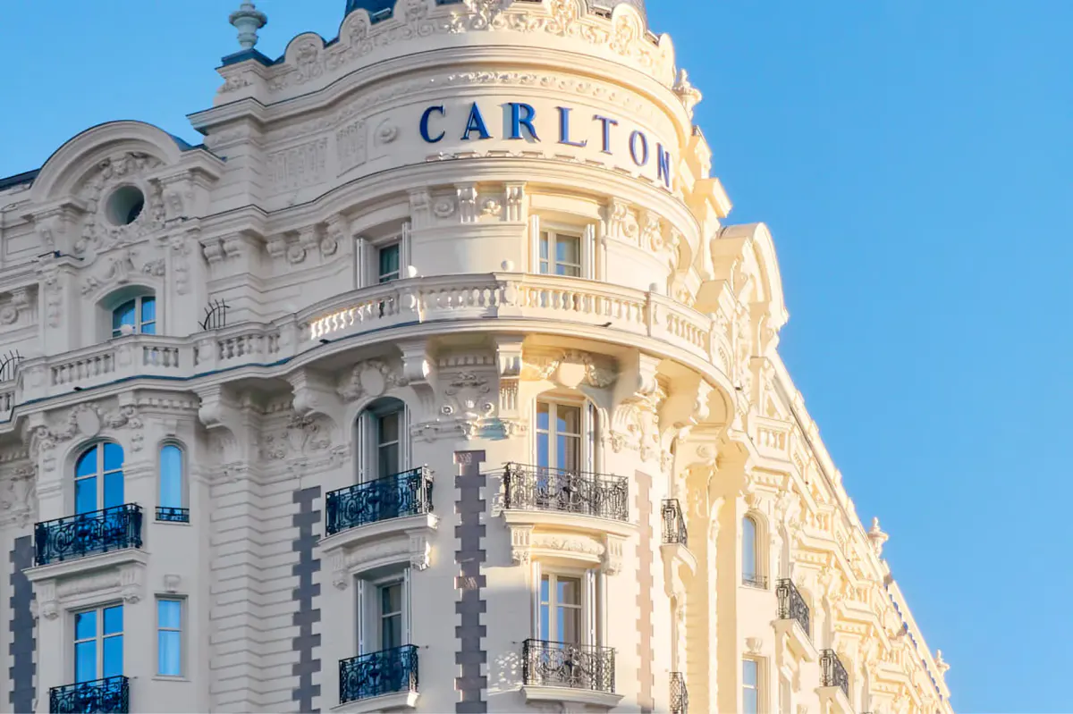 The curved corner facade of Carlton Cannes with limestone detailing and a domed turret element