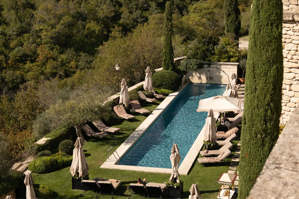 Pool with lounge chairs overlooking cypress-lined valley
