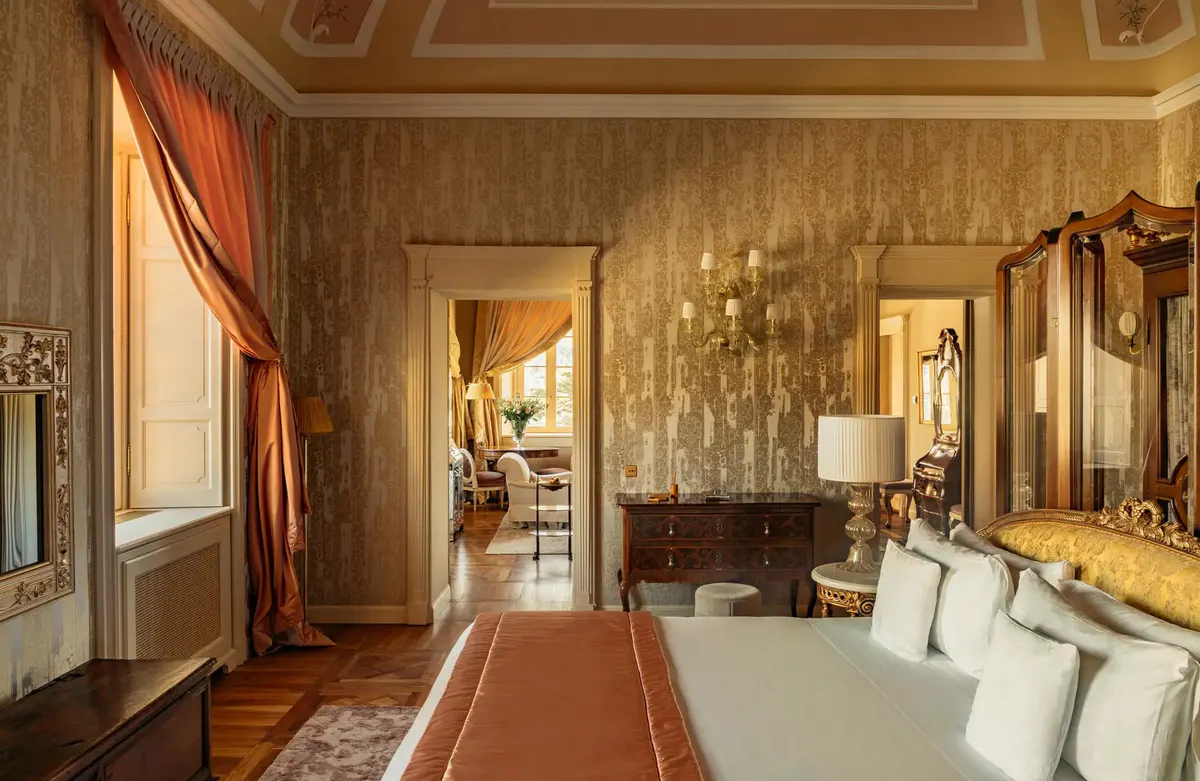 An entry hallway with geometric ceiling, red curtain, and white marble fireplace