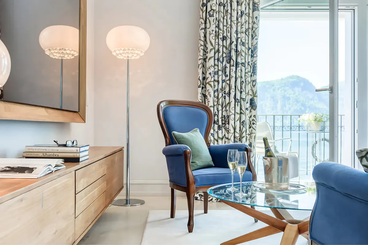 Suite sitting area with blue accent chair and panoramic mountain views