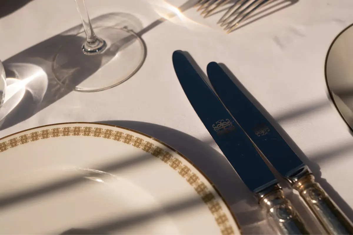 Table setting with fresh herb garnish beside wine and water glasses
