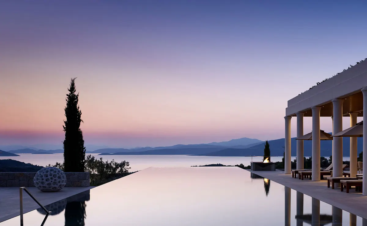 Hillside terrace at sunset with loungers and seascape backdrop