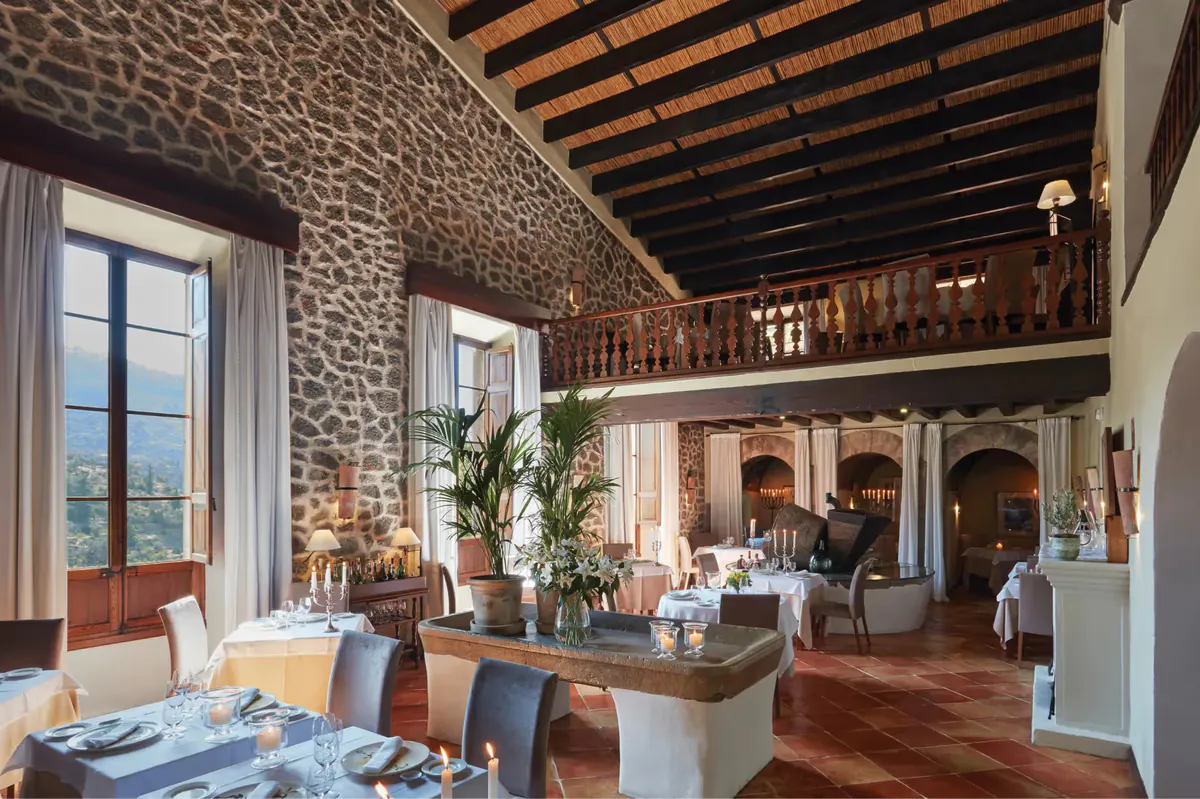 Interior restaurant with stone walls, wooden beam ceiling, gallery level, and Mediterranean ambiance