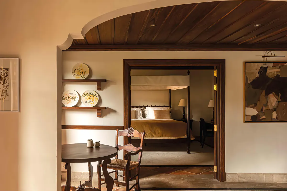 Bedroom with vaulted wooden ceiling, mirrored wardrobe doors, and view to adjoining room