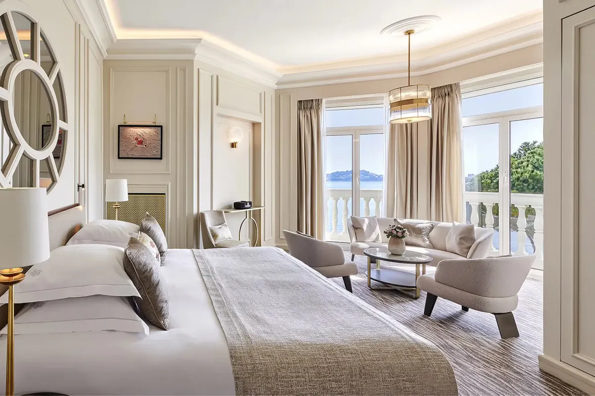 Bedroom with bed facing terrace, natural light, and sea view from balcony