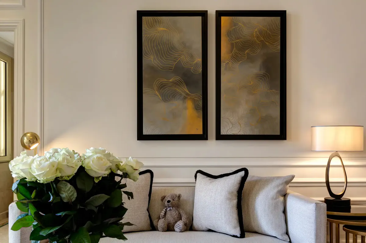 Neutral tone sitting room with white sofa, artwork and sea-view windows