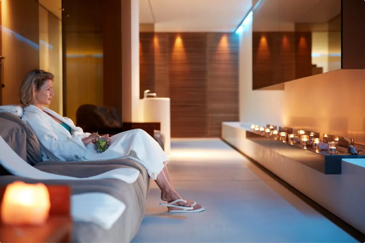 Wellness lounge with two lounge chairs, soft ambient lighting, and fireplace details
