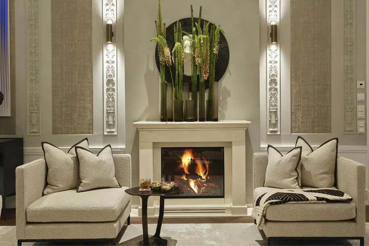 Symmetrical lounge with cream sofas flanking a central fireplace