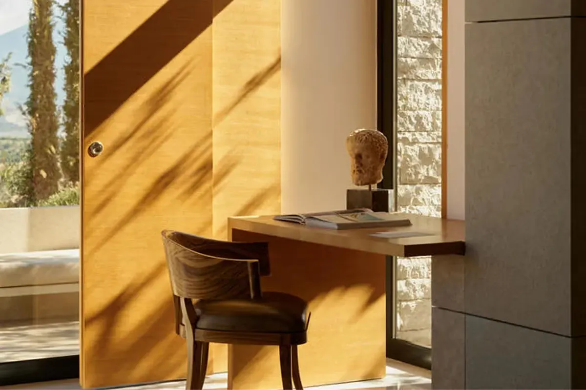 Writing desk in a room with dramatic golden sidelighting and sea views