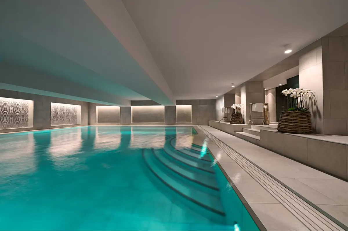 Lap pool corridor with pale walls and reflected turquoise water
