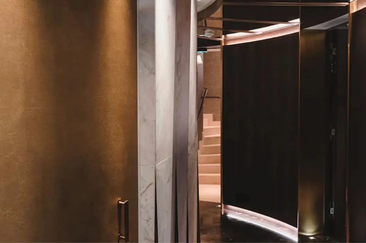 A spa corridor with brass railings and dark walls