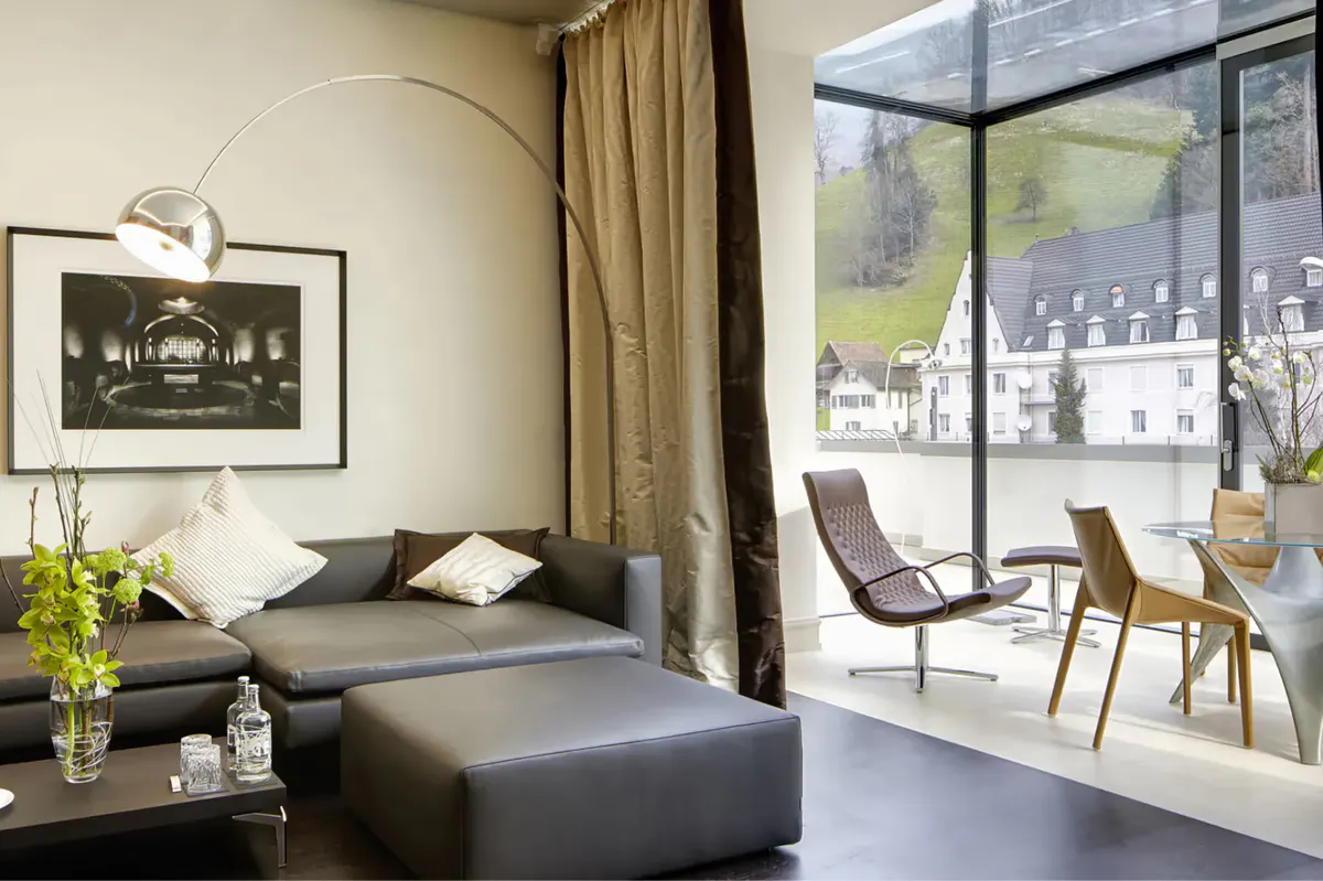 Sitting area with dark seating, large windows framing mountain and lake views