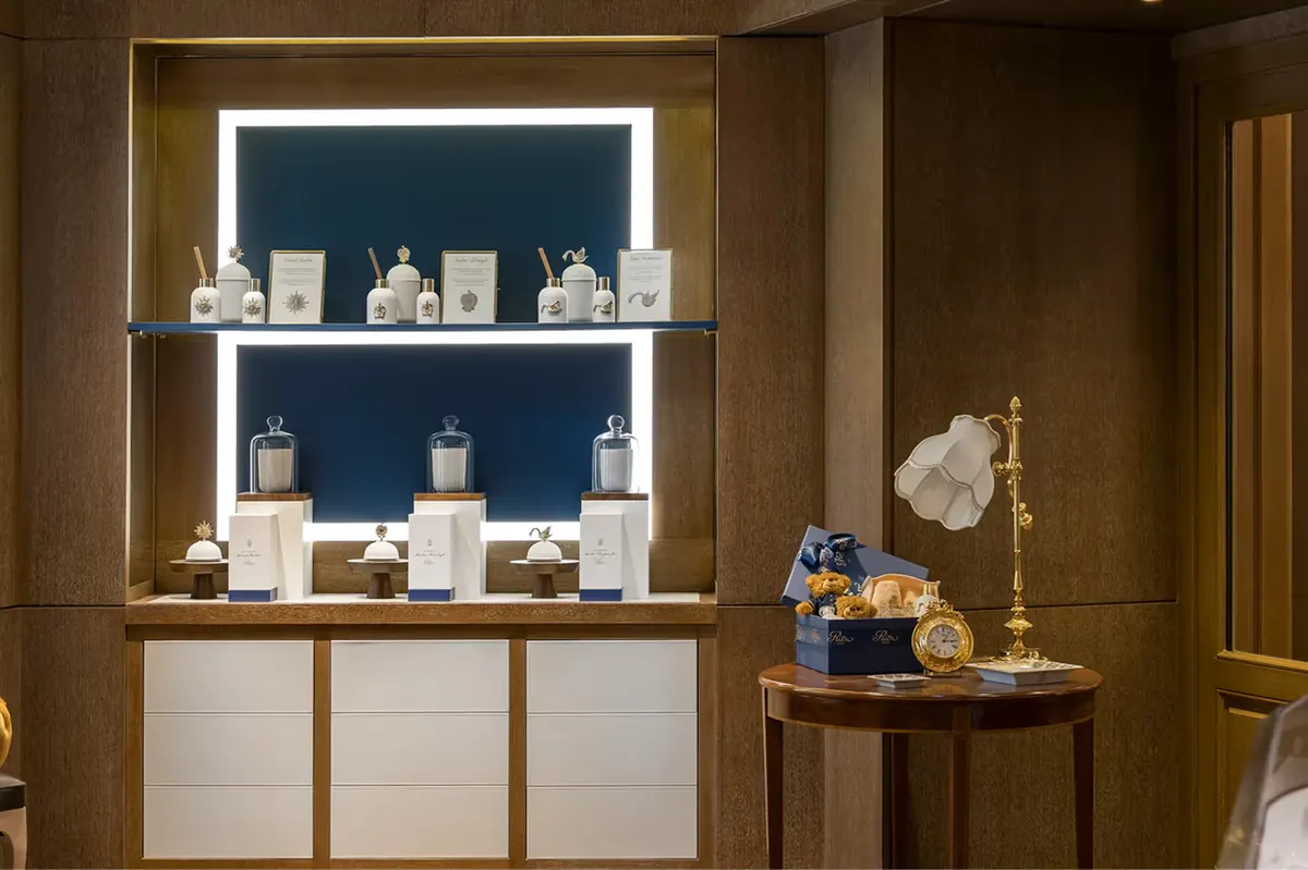 A luxury retail display with illuminated shelving showcasing beauty and jewelry products