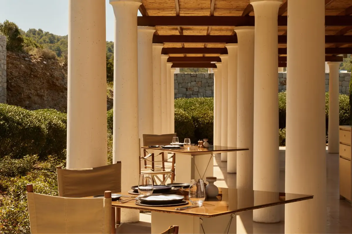 Columned restaurant interior with laid table overlooking countryside