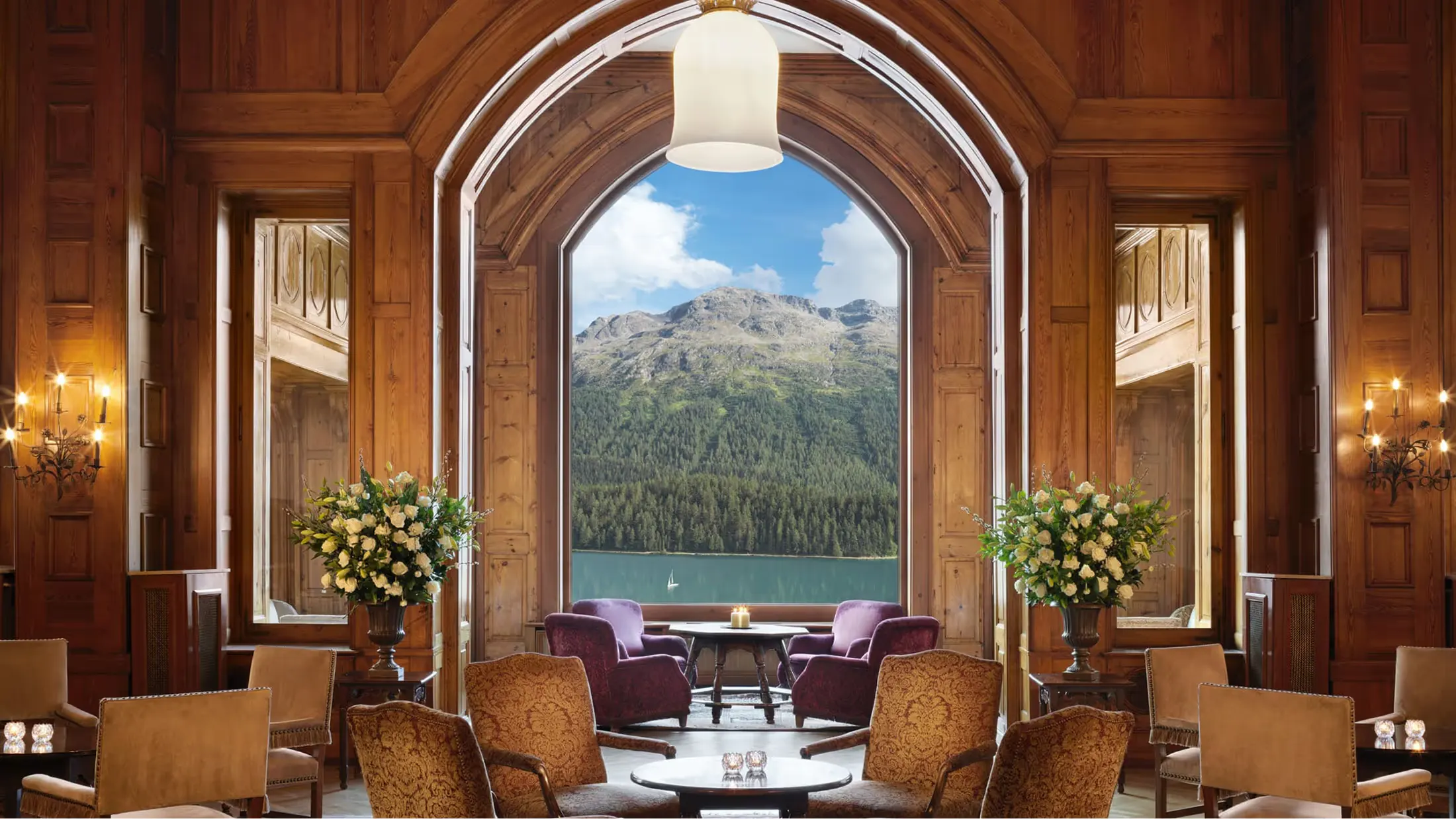 Wood-paneled lounge with arched doorway framing snowy mountain peak