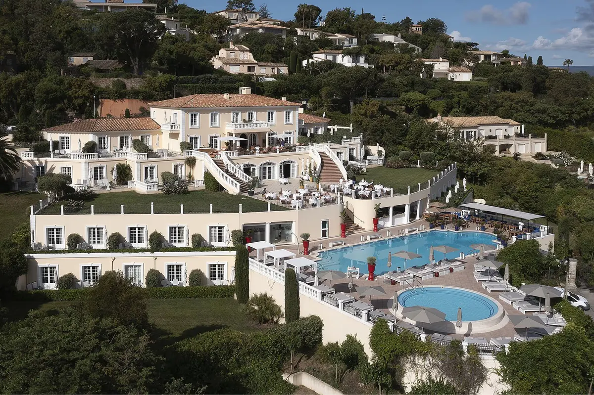 Tiered villa facade with cream stone and swimming pools cascading downhill