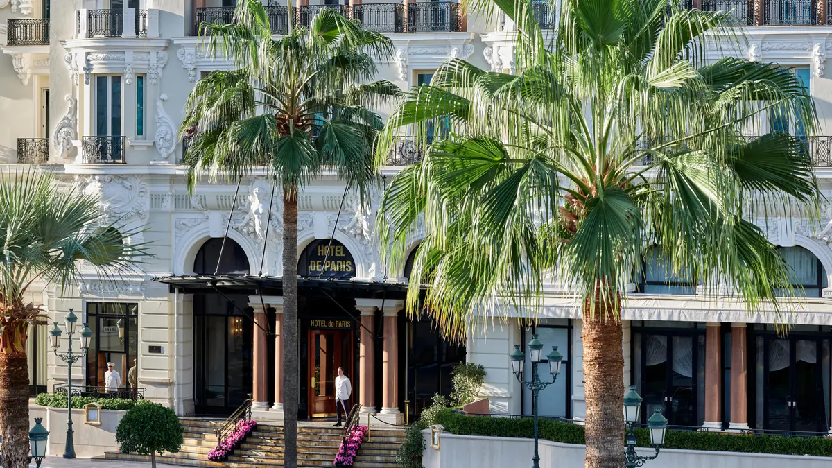 Ground floor entrance with cream columns and palm tree planters