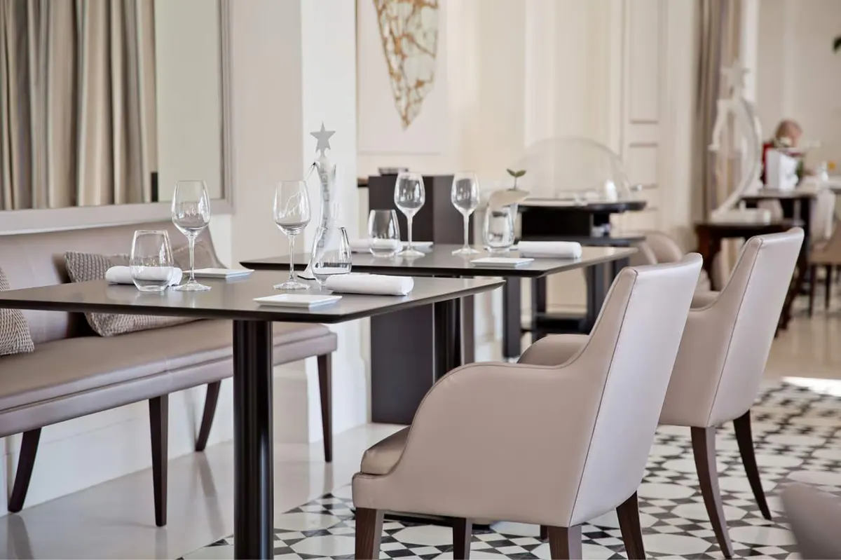 A formal dining room with neutral tones and dark wood accents