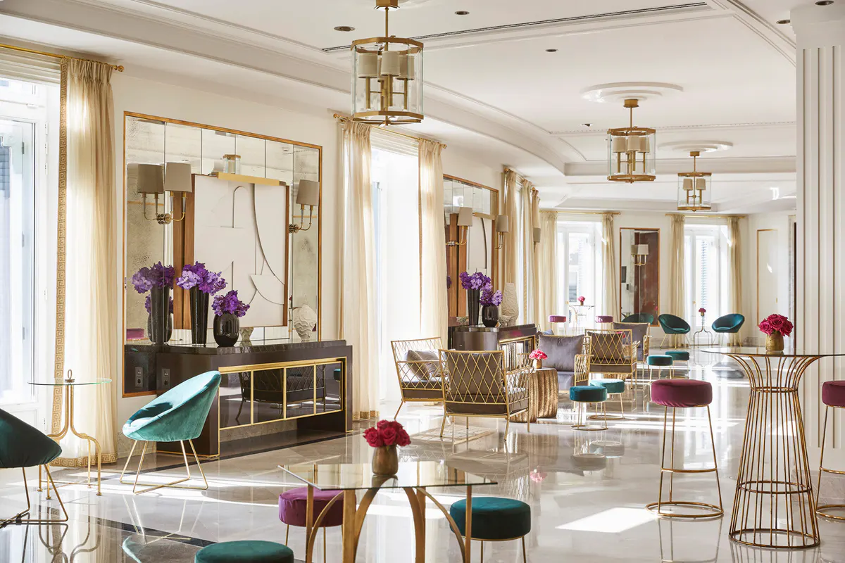 Mirrored spa gallery with white and marble finishes, brass fixtures, and ambient side lighting