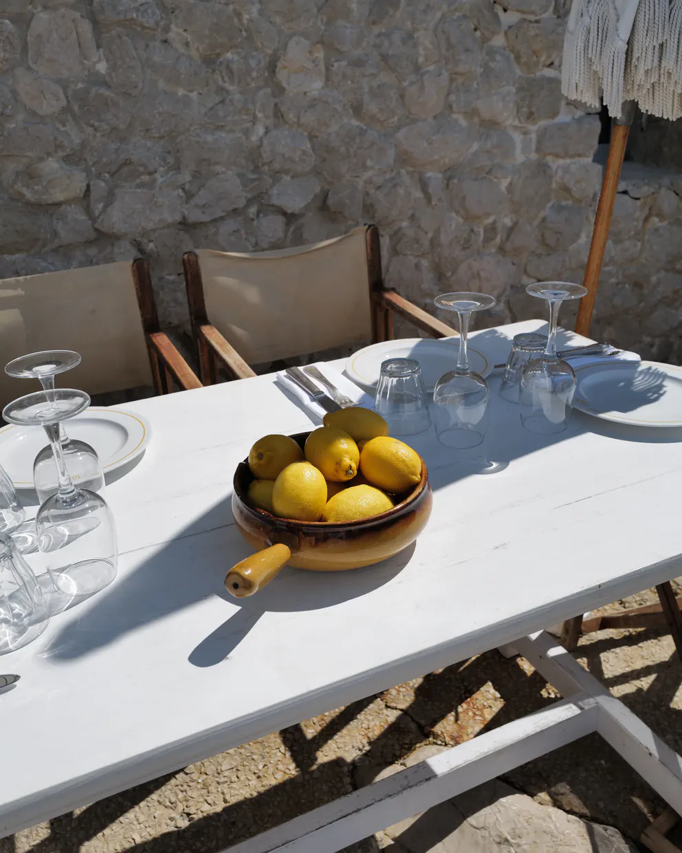 A bowl of lemons on a set table at Tuba Club, against the stone wall