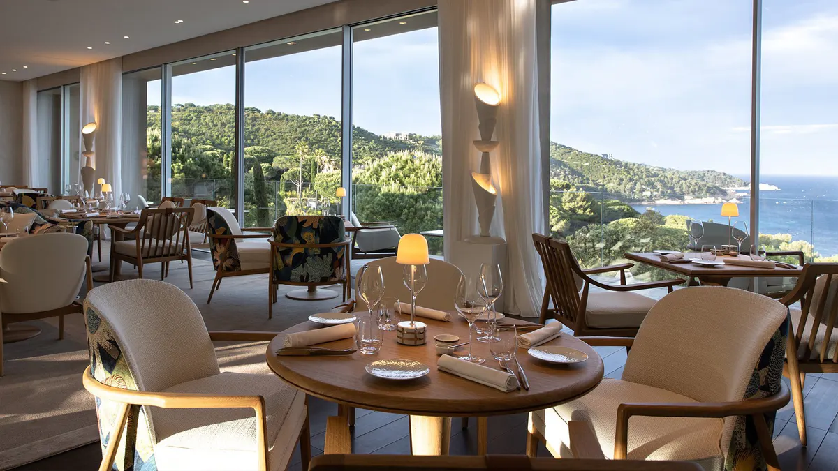 Restaurant with round wood table and floor-to-ceiling views